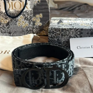 Dior bälte - Ett svart/grå/blå Christian dior bälte som är 90cm helt oanvänd, allt på bilden kommer med, skriv privat för mer info.