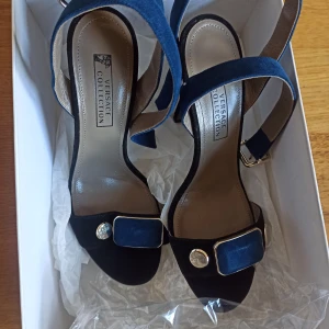 Äkta läder Versace mörkblå och svarta högklackade skor - Oanvända versace klackar av äkta läder från Versace collection room 1006 som jag köpte för 3600 kr. Säljer för att jag har aldrig använt dem.