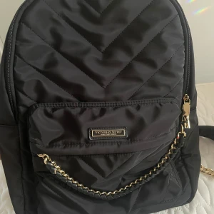  The VS (Victoria Secret) Getaway Travel Backpack - I helt nytt skick. Aldrig använt.  När vi köpte den hade den en liten spegel med sig i väskan som är borta tyvärr. Men väskan är som ny. Den är Victoria secret och är riktig. Kostade 160 sgd som motsvarar ca 112 €. Säljer för halva pris 