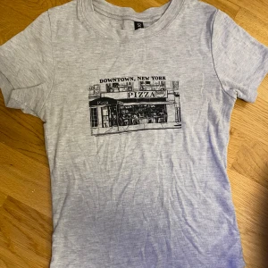 Grå baby-tee  - Söt grå baby-tre med tryck. Lite down-town stil🩷 säljer då den inte kommer till andvändning 