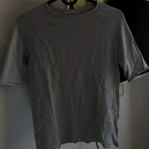 Grå tröja från H&M - Säljer en enkel och stilren grå tröja från H&M. Den är kortärmad och har en rund halsringning. Perfekt för vardagsbruk och kan lätt matchas med olika outfits. Tröjan är i bra skick och redo för en ny ägare!