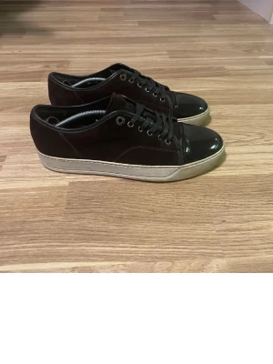 Lanvin Cap toe - Lanvis Cap toe, Vinröda i storlek 42-43. Omhändertagna ganska väl förutom inuti där det har slitit sig men inget som man märker när man har på de. Sulan är lite gul samt nån hint av blå efter förra ägarn men går nog bort efter en tvätt av sulan. Själva tån är i väldigt bra skick och glänser väl med bara lite repmärken som inte är märkvärdiga. Samt ett litet hål i hälen på innersidan. Hör av er om ni hsr några frågor och buda på!