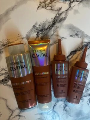 L'Oréal Elvital Growth Booster set - Säljer ett set med L'Oréal Elvital Growth Booster-produkter för hår och hårbotten. Innehåller schampo, balsam och två scalp serum i bronsfärgade och holografiska förpackningar. Perfekt för dig som vill boosta hårväxt och stärka håret.