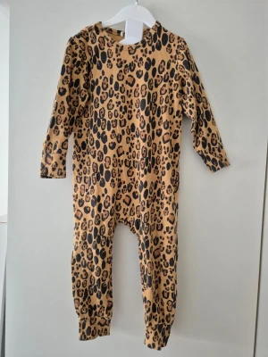 Mini rodini leoprint onesie - Säljer en leoprintad onesie i storlek 80-86. Materialet är mjukt och stretchigt. Använd max en handfull gånger. Hos oss bor inga djur eller rökare.