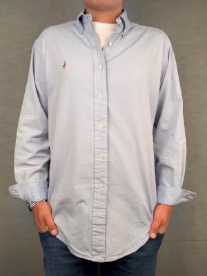  Ralph lauren skjorta  - Säljer denna fantastiska ralph lauren skjorta. Riktigt skönt material. Size 16 1/2 som motsvarar M. Modellen är 180cm. Bredd 51, längd 74cm! Fint skick, nytvättad och ny strykt så att skillnaden på denna och en ny ska vara minimal! Fraktar samma dag som köp, kan gå ner i pris vid snabb affär!