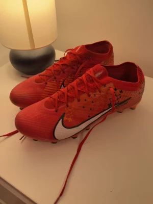 Nike mercurial - Nike Mds Mercurial Vapor 15 Elite FG Dream Speed Light Crimson CR7, nästan helt nya förutom att att plastet på loggan har lossnat av lite men det påverkar inte skorna alls. Fin färg och svåra att få tag i.
