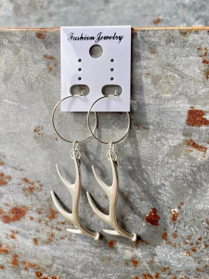 Silvriga örhängen med horn - Unika örhängen i silverfärgad metall med stora ringar och hängande hornformade detaljer. Snygg accessoar för dig som gillar naturinspirerad stil och vill sticka ut lite extra. Perfekta att matcha med både streetwear och mer bohemiska outfits. Total längd är 65 mm