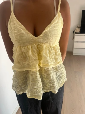 Gul volang topp från Gina tricot  - Söt ljusgul topp med volanger och smala axelband. Säljer denna fina topp jag köpte ifrån Gina tricot förra året. Den är helt oanvänd med prislapp kvar💛