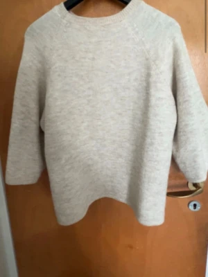 Beige stickad tröja från Gina Tricot - Mysig beige stickad tröja från Gina Tricot i storlek S. Tröjan har en enkel och stilren design med rund halsringning och långa ärmar. Perfekt för lager på lager och passar till det mesta i garderoben.
