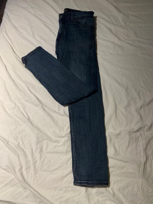 Mörkblå slim fit jeans - Snygga mörkblå raka jeans med klassisk femficksdesign och raka ben. Jeansen har subtila slitningar och kontrastsömmar som ger en modern look. Tillverkade i mjuk denim som sitter skönt hela dagen.