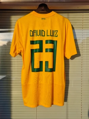 Nike Brasil 2011-2012 - Nike Brasil 2011-2012 David Luiz #23 Lite defekt på nameset fram/baksidan "sista bilder" Skick: 8/10 Storlek: M Produktkod: 405504-703