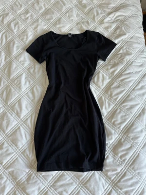 Svart kortärmad tight klänning - En enkel och stilren svart klänning med korta ärmar och rund halsringning. Modellen är tight och kort. 
