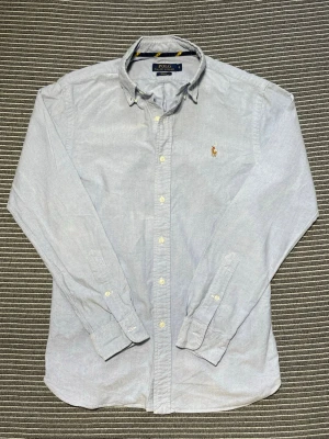 Blå Ralph Lauren Skjorta  - Säljer denna ljusblåa skjorta från Ralph Lauren i storlek S slim fit. Skjortan är i nyskick utan skavanker! | Nypris: ca 1600kr | Om du har frågor eller funderingar så tveka inte på att skriva!🙌