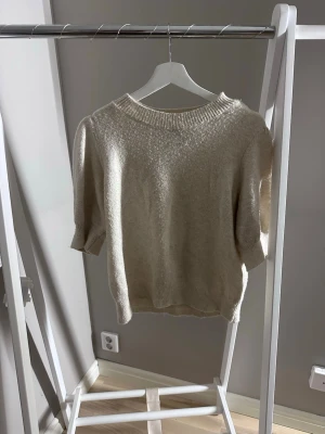 Kortärmad stickad tröja med puffärm - Vit-beige kortärmad stickad, från Vero Moda i storlek L