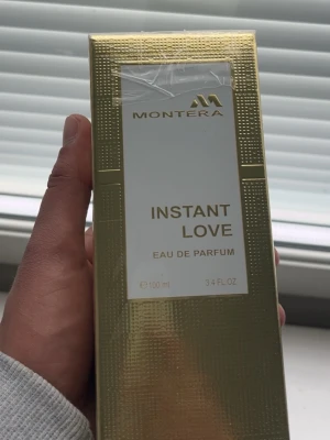Montera Instant Love Eau de Parfum - Lyxig parfym från Montera i en snygg guldig förpackning. Instant Love Eau de Parfum kommer i en 100 ml flaska och har en elegant design med gulddetaljer. Perfekt för dig som vill ha en exklusiv doftupplevelse.