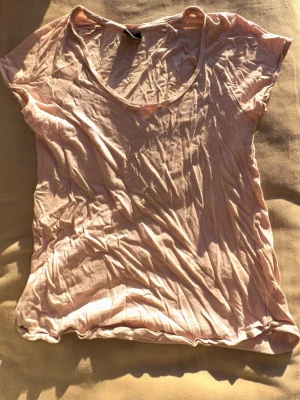 Ljusrosa t-shirt från Gina Tricot - Säljer en enkel och mjuk ljusrosa t-shirt från Gina Tricot. T-shirten har korta ärmar, rund halsringning och är tillverkad i ett tunt, skönt material som passar perfekt till vardags. Snygg att styla med jeans eller kjol. 🌷Spana gärna in mina andra plagg! 🤗