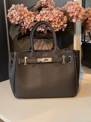 Mörkgrå handväska  - Jätte fin handväska från Don Donna. Super fint skick, använt fåtal gånger❤️Har silver detaljer och är i färgen mörkgrå🥰