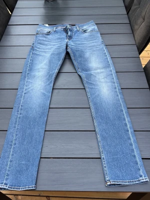 Tiger of sweden Blå raka jeans med slitningar - Snygga blå jeans med raka ben och diskreta slitningar framtill. Jeansen har klassisk femficksmodell och ljus tvätt som ger en avslappnad look. Tillverkade i denim med kontrastsömmar och normal midja. Stl w31 L34