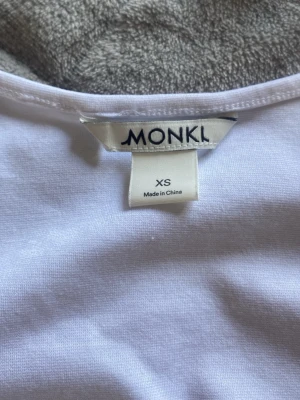 Vit bolerotopp från Monki - Säljer en vit bolerotopp från Monki i storlek XS. Toppen är croppad och har lång ärm, perfekt att slänga över ett linne eller klänning. Tillverkad i mjuk bomull för en skön känsla och enkel stil.