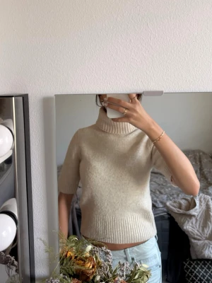 Beige stickad polotröja kort ärm h&m - Säljer en beige stickad polotröja med korta ärmar. inga defekter såsom hål eller fläckar, lite nopprig men det går nog att raka bort 
