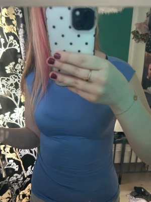 Blå tight ärmlös topp - Säljer en ljusblå, tight och ärmlös topp med rund hals. Toppen har en enkel och clean design utan mönster eller detaljer, perfekt för att matcha med olika stilar.