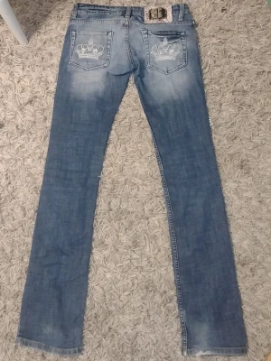 Ljusblå Victoria Beckham jeans med brodyr Rock&Republic  - Säljer ett par ljusblå jeans med raka ben, lite utsvängda och snygg slitning. På bakfickorna finns broderade kronor och loggan 'dvb' i vitt. Jeansen är lågmidjade och har klassiska fickor. Perfekta för en trendig och avslappnad stil. Jag är 168 cm å de passar nästan perfekt, aningen långa men supersnygga ändå! De är storlek 27 å passar en 32-34a, typ xxs,xs. Säljs för att jag inte använder dom mer. 💕