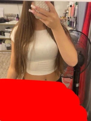 Vit croppad topp med kort ärm - Säljer en enkel och stilren vit croppad topp med korta ärmar. Toppen har en tight passform och är perfekt till sommaren. Passar dig som gillar en basic look och vill ha något som är lätt att matcha med olika outfits.