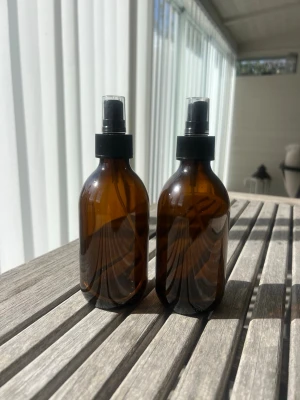 Två bruna sprayflaskor i glas - Säljer två stilrena sprayflaskor i brunt glas med svart spraymunstycke och genomskinligt lock. Perfekta för hemmagjorda produkter, växtspray eller rengöring. Rymmer 250 ml och har en enkel, modern design som passar i alla rum. Går även att använda som vas💕🌷