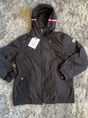 Moncler windbraker - Riktigt snygg svart windbraker. Helt ny. Storlek L fast sitter som M. Den är som en M