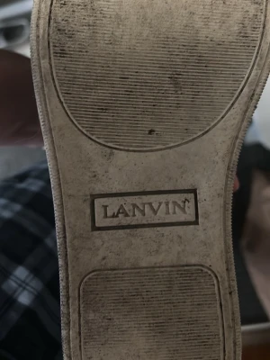 Marinblå Lanvin sneakers i läder - Stilrena marinblå sneakers från Lanvin med ovandel i läder och mocka, vita gummisulor och svarta skosnören. Klassisk låg modell med rund tå och utbytbara innersulor i beige läder. Perfekta för en clean och tidlös look.