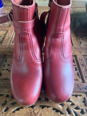 Swedish Hasbeens Nacka Boots -  – stl 39 – nyskick Säljer ett par Swedish Hasbeens Nacka Boots i vacker ceriseröd/burgundy färg. Storlek 39. Endast provade inomhus Nyskick Äkta skinn och träsula Klassisk Swedish Hasbeens-modell med hög träklack 