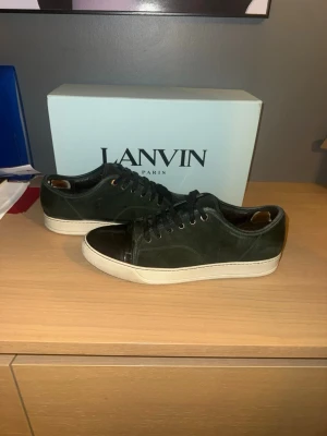  Lanvin skor - Säljer dessa Snygga ovanliga sneakers från Lanvin . Skorna har vita sulor och grön mocka. Klassisk låg modell som passar till många olika stilar. Kommer med originalkartong. Använt sick men ser väldigt fräsch ut lite slitna skosnören och inne vid hälen men inget som märks av. Sickar även med ett par andra skosnören som kan sättas på annars finns de väldigt liknade att köpa i andra butiker. Hör av er vid frågor. Storlek 43-uk9