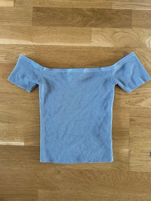 Ljusgrå offshoulder topp Divided - Trendig ljusgrå offshoulder topp från Divided. Toppen är ribbad och har korta ärmar😊