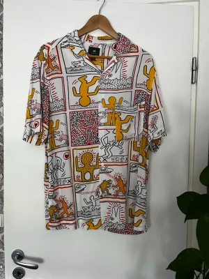 Keith Haring skjorta - Kortärmad skjorta med Keith Haring motiv. Bara anddvänt 2-3 gånger.