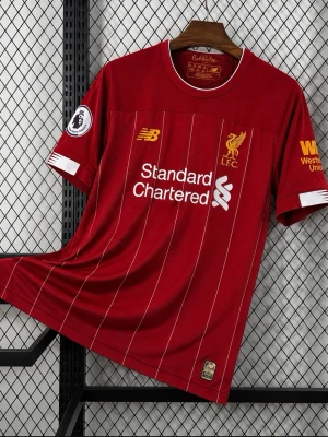 Liverpool matchtröja röd New Balance - Liverpool FCs officiella matchtröja i rött med vita tunna ränder, klubbmärke och sponsortryck framtill. Kort ärm, rund hals och tryck på ryggen med Alexander-Arnold och nummer 66. Tillverkad i lätt och ventilerande material, perfekt för fotboll eller träning.