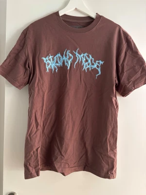 Brun Astroworld tour t-shirt - Säljer en brun Astroworld tour t-shirt med tryck i blått och vitt framtill och stort färgglatt tour-tryck på ryggen. T-shirten har normal passform och är gjord i mjuk bomull. Perfekt för dig som gillar streetwear och vill sticka ut.