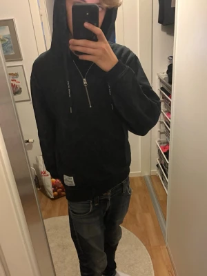 Svart hoodie från Replay med tryck - Cool svart hoodie från Replay med texten 'REPLAY NOT ORDINARY' på ryggen. Hoodien har dragkedja vid halsen, huva med snören och en liten patch nertill. Storleken är S och tröjan är i ett som nytt skick. Skriv vid frågor eller funderingar!