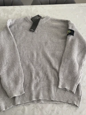Ljusgrå stickad Stone Island tröja - Ljusgrå stickad Stone Island tröja i storlek L