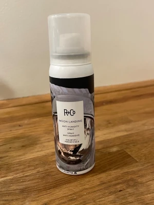 R+Co Moon Landing Anti-Humidity Spray - R+Co Moon Landing Anti-Humidity Spray är en hårspray som motverkar friss och skyddar mot fukt. Kommer i en vit och svart sprayflaska med ett futuristiskt motiv på etiketten. Perfekt för att hålla frisyren på plats även vid hög luftfuktighet.