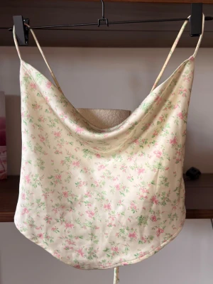 Falling flowers topp || Gina Tricot - Söt sommar topp från Gina Tricot i silkes liknande material. Toppen har öppen rygg med bara rosett funktion och tunna söta axelband. Perfekt för varma dagar och enkel att styla med jeans eller kjol. Toppen är absolut med gyllen i tonen,                                       ⭐️Säljes i använt skick,  använd en gång på stan                                                                         💭Har du frågor? Skriv på annonsen och jag svarar så fort jag kan!