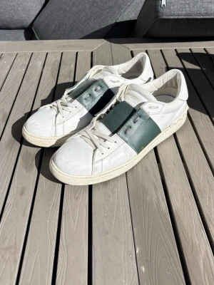 Vita sneakers med grön detalj - Valentino open. Storlek 45. Skick: 7/10, se bild 3. Retail 6,500 SEK.