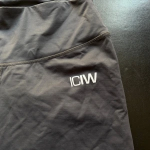 Mörkgrå träningstights från ICANIWILL - Snygga mörkgrå träningstights från ICANIWILL med hög midja. Stretchigt material och sinch/rynkning i rumpan. Sitter jättesnyggt och är väldigt bekväma.