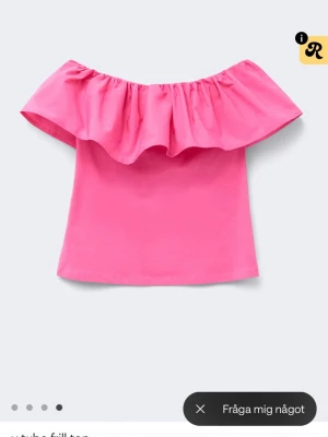 Rosa offshoulder topp med volang - Snygg rosa offshoulder topp med bred volang runt hela axelpartiet. Toppen är ärmlös och har en croppad känsla, perfekt för varma dagar. Enkel att styla med jeans eller kjol. Helt oanvänd då jag beställde fel storlek🌸 superfin!!! Bara hunnit dra av prislappen men helt oanvänd🥰