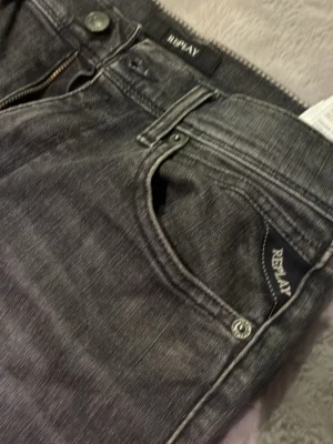 Replay jeans - Säljer ett par gråa jeans från Replay med en klassisk femficksdesign. Jeansen har snygg tvättad look och detaljerade sömmar. Materialet är mjukt denim som ger en bekväm känsla och cool stil.