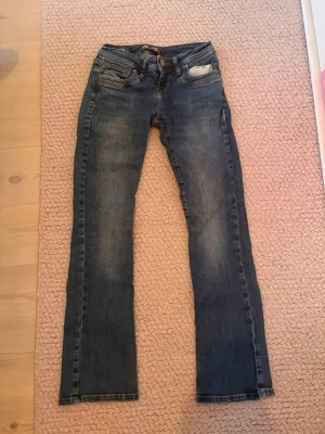 Blå jeans low waist LTB med utsvängda ben - Snygga blå jeans från LTB med låg midja och klassisk femficksmodell och utsvängda ben. Jeansen har en lätt tvättad look och detaljerade sömmar. Perfekta för en avslappnad stil och passar till det mesta. Materialet är denim. De har mycket bra passform och sitter bekvämt. Köpta på Zalando för ca. 800kr. Hör av dig vid frågor🥰🥰