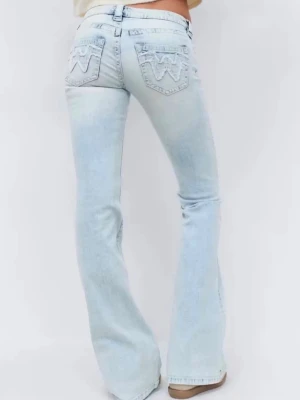 Ljusblå bootcut jeans  - Säljer ett par ljusblå bootcut jeans med snygga broderade detaljer på bakfickorna. Jeansen har låg  midja, klassisk femficksdesign och är i storlek S. Perfekta för en avslappnad och trendig look. Som man kan se på bild 4 har ena byxbenet gått sönder men byxorna går jättebra att använda ändå💕