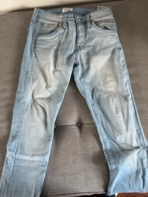 Ljusblå raka jeans - Säljer ett par ljusblå jeans med raka ben och klassisk femficksmodell. Jeansen har en snygg tvättad look och kontrastsömmar på bakfickorna. Perfekta för en avslappnad och trendig stil. Materialet är mjukt denim i bomull.