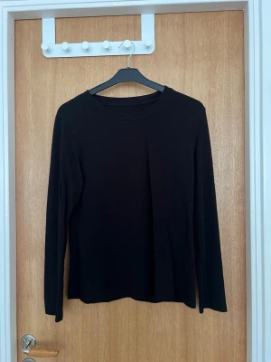 Svart långärmad topp - En enkel och stilren svart långärmad topp med rund hals. Perfekt basplagg som passar till det mesta och är lätt att matcha med olika outfits. Tillverkad i mjukt material för en bekväm känsla.
