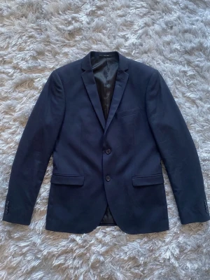 Tiger of Sweden kavaj i nyskick – Mörkblå / Navy - Säljer en stilren mörkblå kavaj från Tiger of Sweden i absolut nyskick! Klassisk modell med riktigt snygg passform och hög kvalitet. Perfekt till höstens alla tillfällen, skolan, jobbet eller när du vill klä upp dig lite extra. 