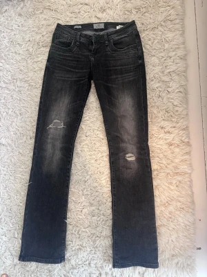Svarta slitna jeans - Snygga svarta ltb valerie jeans med slitningar på båda benen och klassisk femficksmodell. Jeansen har en tvättad look och raka ben. Perfekta för en avslappnad och trendig stil.